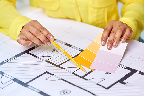 interior design, architecture and people concept - close up of architect's hands working with blueprint, pencil and color palettes
