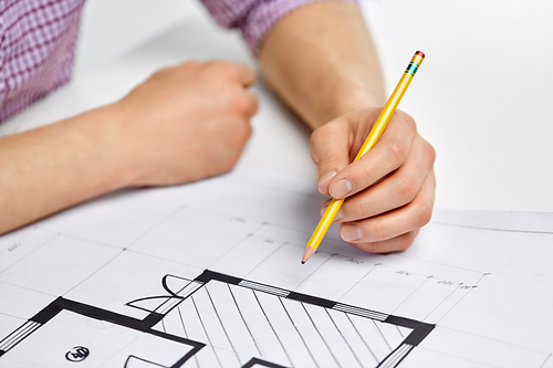 business, architecture and people concept - close up of architect's hand working with blueprint and pencil