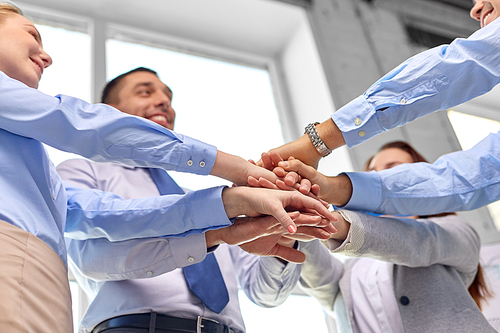 gesture, people and teamwork concept - close up of business team stacking hands at office