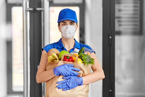 health protection, safety and pandemic concept - delivery woman in face mask and gloves holding paper bag with food