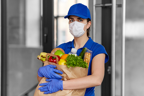 health protection, safety and pandemic concept - delivery woman in face mask and gloves holding paper bag with food