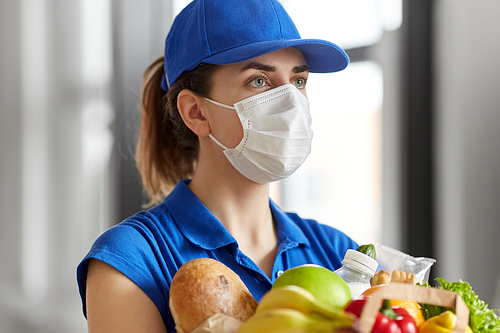 health protection, safety and pandemic concept - delivery woman in face mask and gloves holding paper bag with food