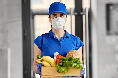 health protection, safety and pandemic concept - delivery woman in face mask and gloves holding wooden box with food