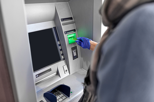 finance, bank and hygiene concept - close up of woman in medical glove with credit card at atm machine