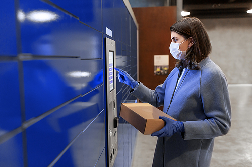 health care, mail delivery and pandemic concept - woman wearing face protective medical mask for protection from virus disease with box at automated parcel machine