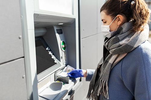 finance, bank and hygiene concept - woman in medical mask and glove with cash money at atm machine