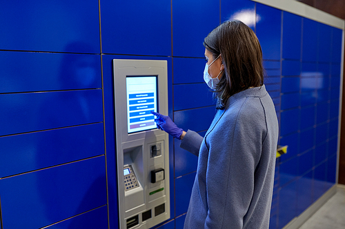 health care, mail delivery and pandemic concept - woman wearing face protective medical mask for protection from virus disease at automated parcel machine