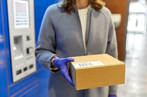 health care,  delivery and pandemic concept - close up of woman in protective medical gloves for protection from virus disease with boxes at automated parcel machine