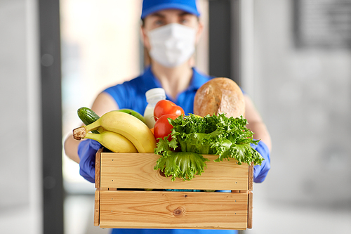 health protection, safety and pandemic concept - delivery woman in face mask and gloves holding wooden box with food