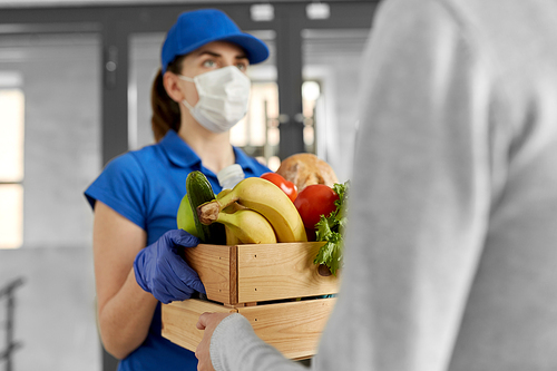 health protection, safety and pandemic concept - delivery woman in face mask and gloves giving wooden box with food to female customer