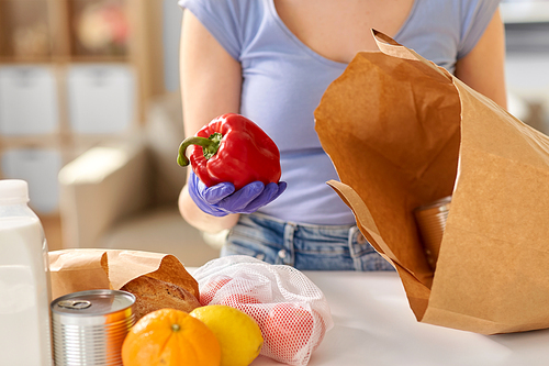 health protection, safety and pandemic concept - close up of woman in protective medical gloves taking food from paper bag at home