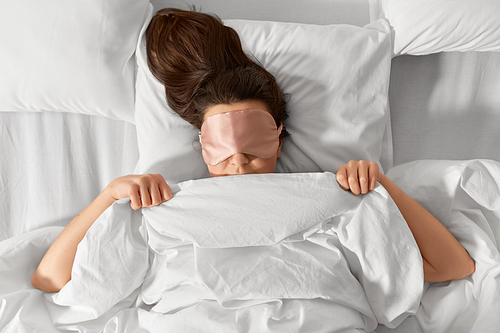 people, bedtime and rest concept - woman with eye sleeping mask lying in bed under blanket