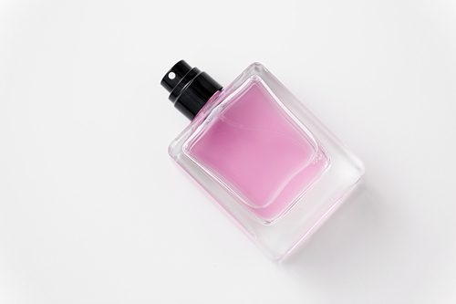 fragrance and aroma concept - bottle of perfume or pink toilette water on white background