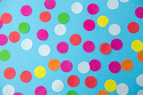 party, celebration and decoration concept - colorful confetti on blue background