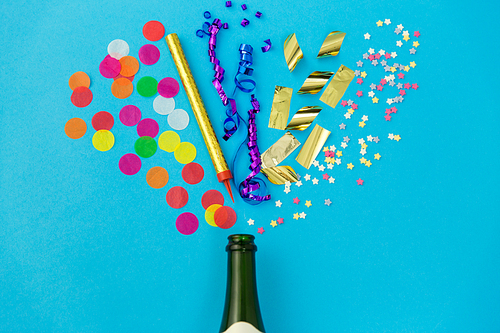 celebration and decoration concept - champagne bottle and birthday party props on blue background