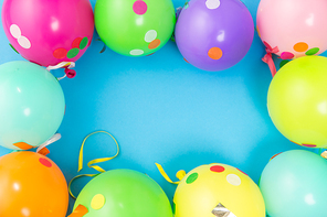 party props, celebration and decoration concept - colorful balloons and confetti on blue background
