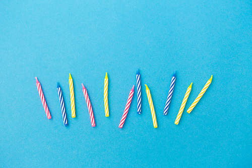 holiday, celebration and party concept - birthday candles on blue background