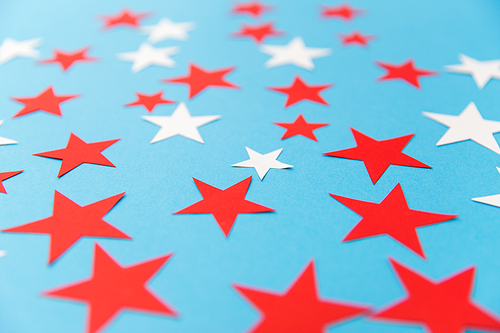 party, celebration and decoration concept - star shaped confetti on blue background