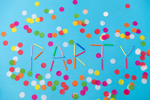 celebration, holiday and lettering concept - word party made of colorful birthday candles and confetti on blue background