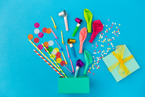 celebration and decoration concept - gift box and birthday party props on blue background