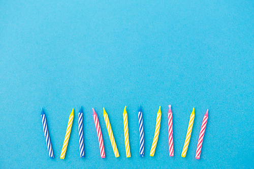 holiday, celebration and party concept - birthday candles on blue background