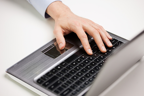 business, people and technology concept - close up of businessman hand typing on laptop computer keyboard at office