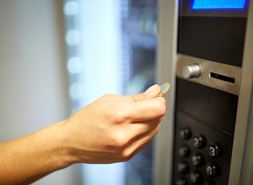sell, technology, people, finances and consumption concept - hand inserting euro coin to vending machine