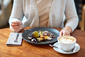 food, new nordic cuisine and people concept - woman eating chocolate ice cream dessert with blueberry kissel, honey baked fig and greek yoghurt with coffee at cafe