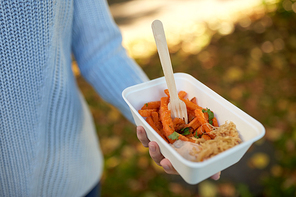 fast food, people and unhealthy eating concept - close up of hand holding disposable plate with sweet potato and fork