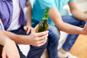 alcohol and people concept - men with beer bottles sitting on sofa at home