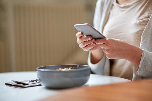 food, technology, eating and people concept - woman with smartphone and bowl of soup sitting at cafe table