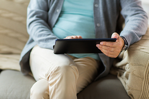 technology, old age, people and lifestyle concept - close up of senior man with tablet pc computer sitting on sofa