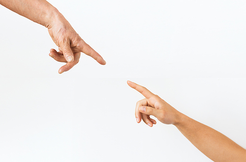 people, age and body parts concept - close up of senior and young woman hands pointing finger