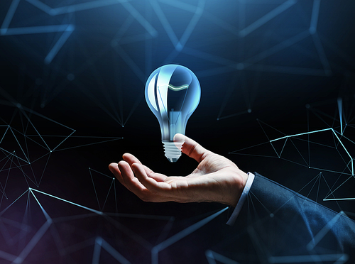 business, innovation, people and startup concept - close up of businessman hand with light bulb over dark background