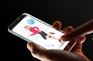 sport, people and future technology concept - close up of hands with fitness application transparent smartphone over black background