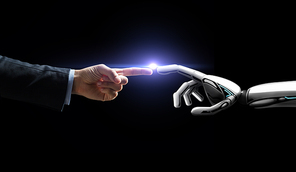 artificial intelligence, future technology and business concept - robot and human hand with flash light over black background