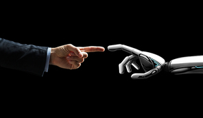 artificial intelligence, future technology and communication concept - robot and human hand connecting fingers on black background