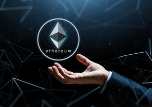 cryptocurrency, financial technology and business concept - businessman hand with ethereum hologram over black background with low poly hologram