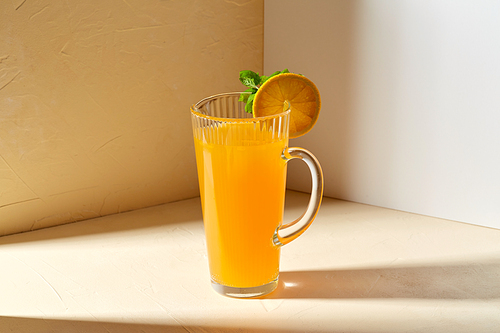 drink, detox and diet concept - glass jug with fruit orange juice and peppermint on table
