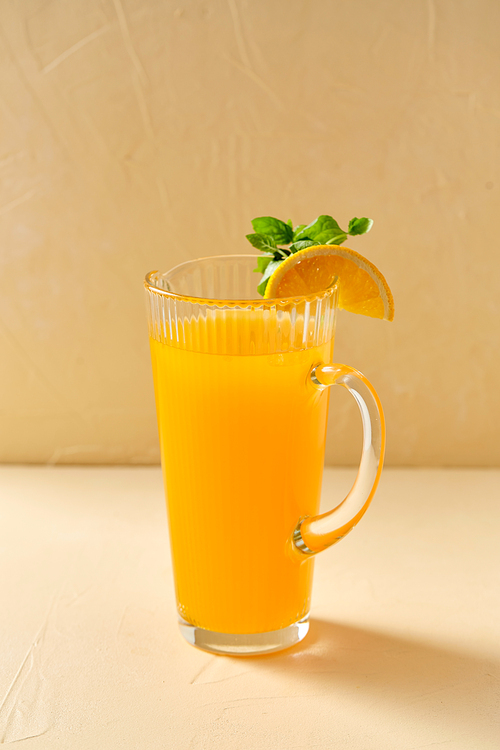 drink, detox and diet concept - glass jug with fruit orange juice and peppermint on table