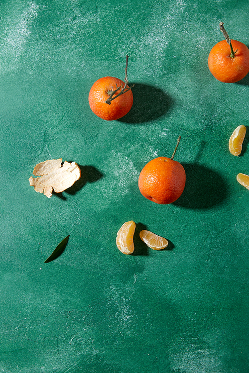 food, healthy eating and fruits concept - still life with mandarins on green background