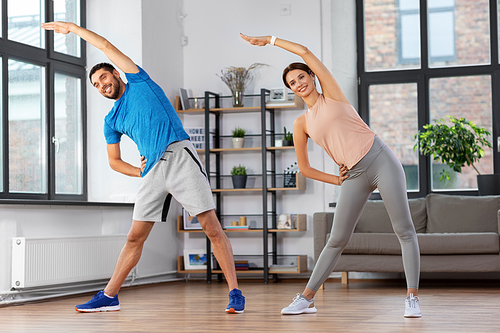sport, fitness, lifestyle and people concept - smiling man and woman exercising at home