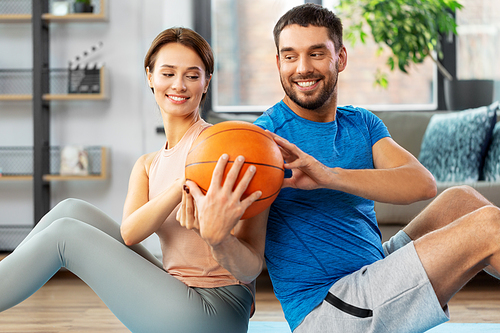 fitness, sport and healthy lifestyle concept - happy couple exercising with ball at home
