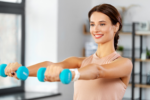 fitness, sport and healthy lifestyle concept - happy woman with dumbbells exercising at home
