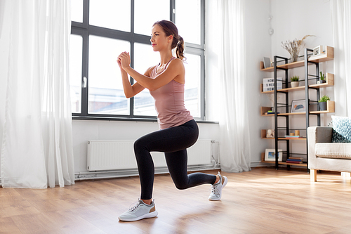 sport, fitness and healthy lifestyle concept - young woman exercising at home