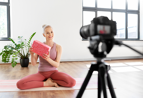fitness, sport and video blogging concept - woman or Vlog with camera and block streaming online yoga class at home