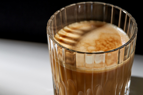 caffeine, objects and drinks concept - close up of coffee in glass on table