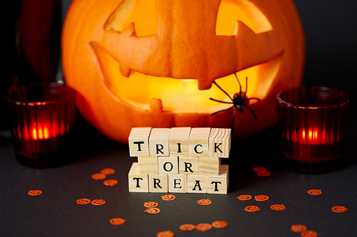 halloween,  holidays and decorations concept - wooden toy blocks with trick or treat letters on table