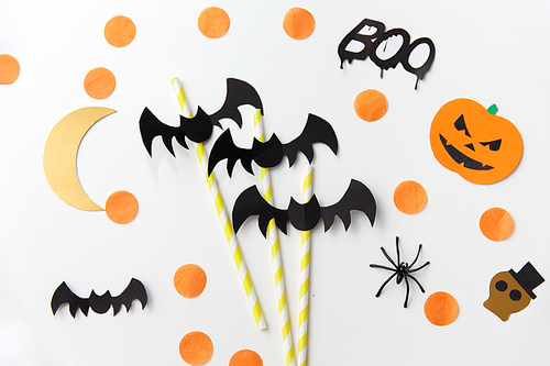 holidays and decorations concept - halloween party props and paper straws over white background