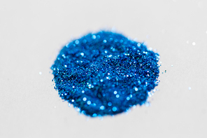 party, decoration and holidays concept - blue glitters on white background